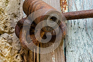 Lock on an old wooden door with rusty inserts