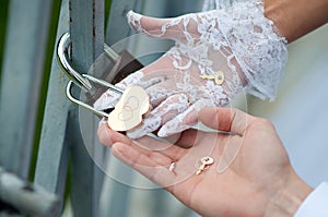 Lock in shape heart with keys, bride and groom hands