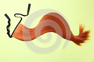 Lock of straight red hair on color background