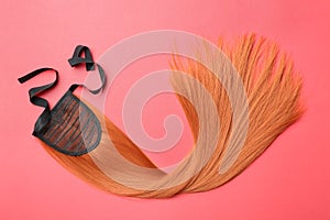 Lock of straight red hair on color background