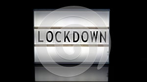 Lockdown letters on a light box on reflective surface