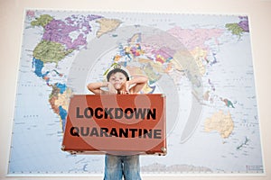 Lockdown quarantine cancel travel concept of little caucasian boy in captain hat holding case with slogan on world map background