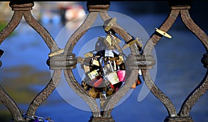 Locked - Close up of a metal grate with added padlocks, with the blue river in the background, in the sunny day