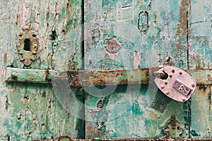 Locked door. Closed old rusty padlock on a distressed wooden door