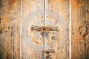 Locked door. Closed old rusty padlock on a distressed wooden door