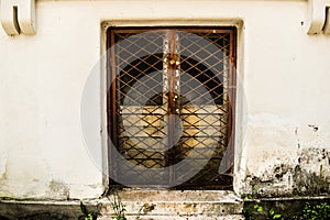 Locked door with iron fence keeping secrets inside the grunge building in the forbidden place