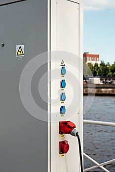 Locked electric panel with attention sign on great wall of transformer substation. High voltage sign. Electrical sockets