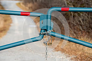 Locked gate blocking a gravel road