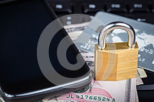 Locked padlock, phone, credit card and money on a computer keyboard