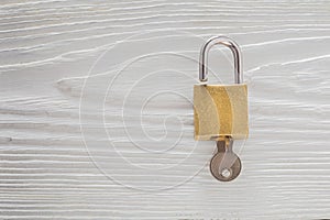 Locked padlock with silvered keys on white wooden background. Estate and security concept with symbol of protection.