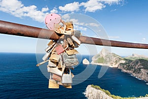 Locked padlocks on a rail overlooking the ocean