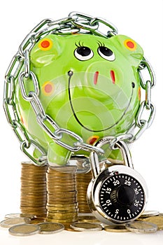 Locked piggy bank on coins