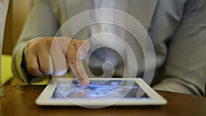 Locked-on shot of a businessman sitting in a Cafe and using a digital tablet