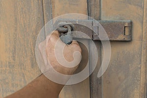 Locked vintage wooden door with hand