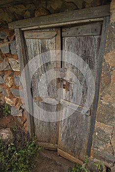 Locked wooden door of an old abandoned shanty house in rural India.