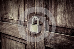 Locked wooden door with silver padlock