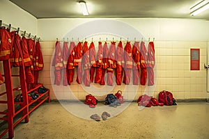 Locker room of a fire department with protection uniforms and helmets. Neural network AI generated