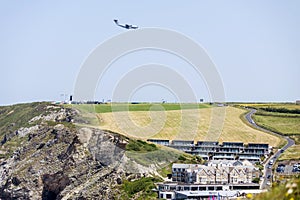 Lockheed C-130 Hercules flying over Newquay bay and cliffs on a summer morning,Cornwall,England,UK