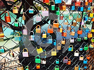 Locks of love on a metal mesh. Many colorful beautiful castles were left by young wives and lovers. Locks hang from the