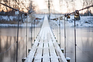 Locks on a rope bridge over frozen water