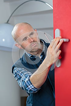 Locksmith man fix door with screwdriver