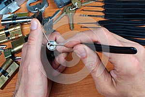 Locksmith picks a cylinder lock with lockpick and tension wrench