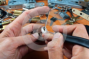 Locksmith picks a cylinder lock with lockpick and tension wrench