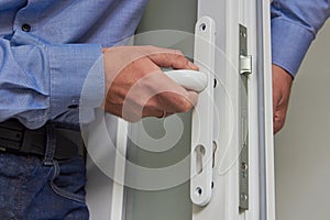 locksmith repairs plastic doors,a professional carpenter installs a new door handle and lock in the door