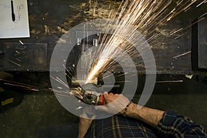 Locksmith whetting metal with flying sparks