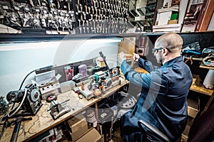 Locksmith working on key duplicating machine in workshop