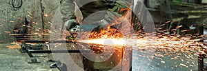 Locksmith works in production. Metal processing with angle grinder. Sparks in metalworking.