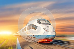Locomotive high speed train runs on rail track, sunset sky