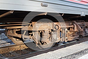 Locomotive on railway station, iron train wheels mechanism close up, steel rail wheel construction, railroad wagon part