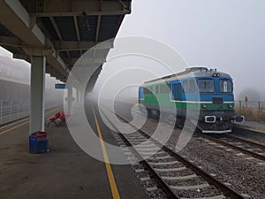 Locomotive stationed in the train station on a foggy autumn day