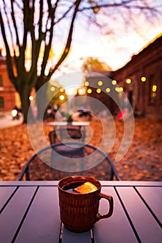 Lodz, Poland: A cup of hot drink on the table in the Ksiezy Mlyn historic distric during autumn evening