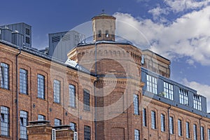 Facade of restored building of former textile factory in urban complex Ksiezy Mlyn (Priest's Mill), Lodz, Poland