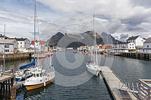 Lofoten, Norway - June 20, 2017: Colorful fishing harbor Henningsvaer on Lofoten Islands in Norway with mountains towering in the