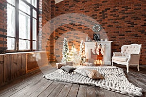 Loft apartments, brick wall with candles and Christmas tree wreath. White wool socks for Santa on the fireplace. Knitted