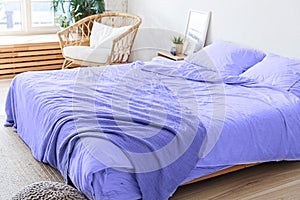 Loft bedroom interior, bed linen colored in trendy color of year 2022 Very Peri background. Inspired by using color 17 photo