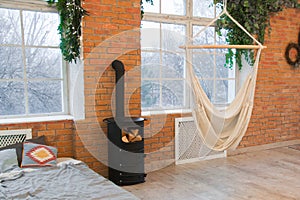 Loft design of interior bedroom studio with wall of bricks and hammock and plants