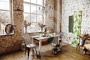 Loft interior with brick wall, table and chairs