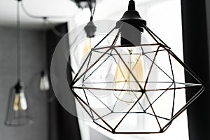 Loft style iron lampshade with a light bulb in the interior living room in modern apartment. Vintage style light bulbs