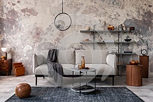 Loft style of modern apartment with grey design sofa, coffee table, bookstand, pedant lamp, carpet, decoration and elegant