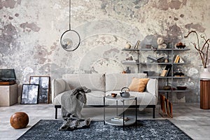 Loft style of modern apartment with grey design sofa, coffee table, bookstand, pedant lamp, carpet, decoration and elegant photo