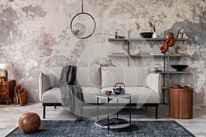 Loft style of modern apartment with grey design sofa, marble coffee table, bookstand, pedant lamp, carpet, decoration and elegant photo