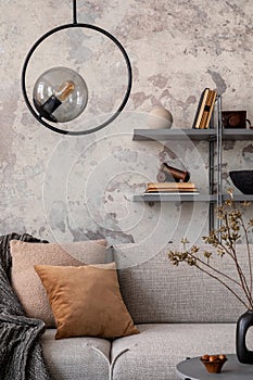 Loft style of modern apartment with grey design sofa, plants, tea pot, bookstand, pedant lamp, carpet, decoration, pillows and photo