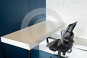 Loft style office with white brick walls and concrete columns. There is a meeting area with a large white table with black chairs