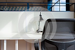 Loft style office with white brick walls and concrete columns. There is a meeting area with a large white table with chairs