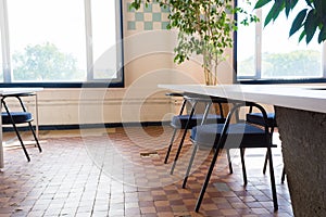 Loft style office with white brick walls and concrete columns. There is a meeting area with a  white table with black chairs