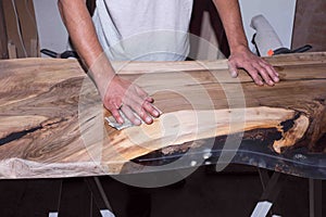 Loft table with epoxy resin in the workshop. black resin with stones inside.